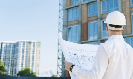 back view man holding building plans