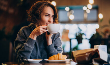 young woman eating croissants cafe