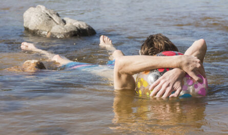man with ball lying water