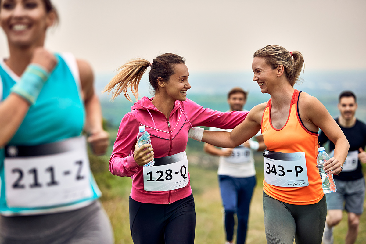 scastlivye sportsmenki podderzivaut drug druga vo vrema marafona na prirode