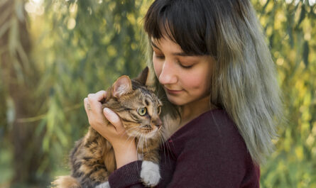 young beautiful woman with her lovely tabby cat park