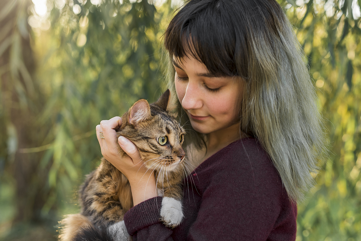 young beautiful woman with her lovely tabby cat park