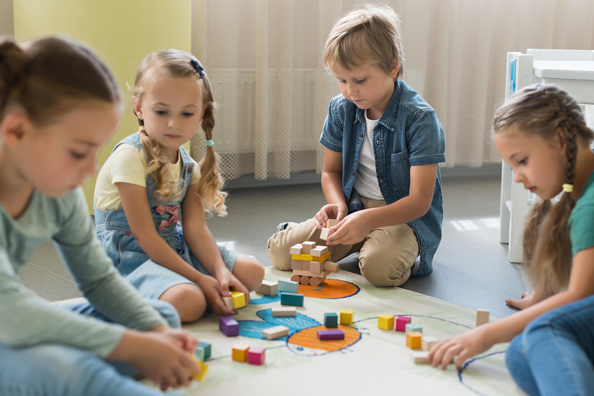 front view children playing together kindergarten
