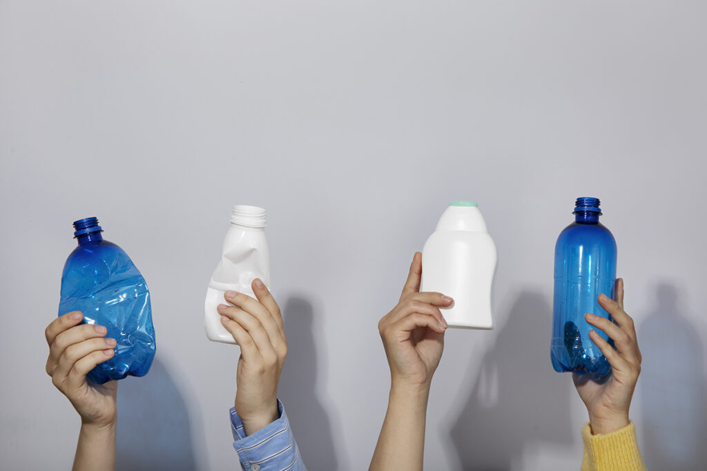 people holding plastic bottles minimal recycling