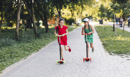 two girls enjoying riding push scooter park