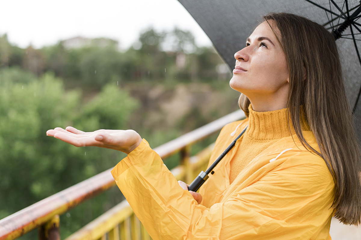 woman feeling rain with her hand