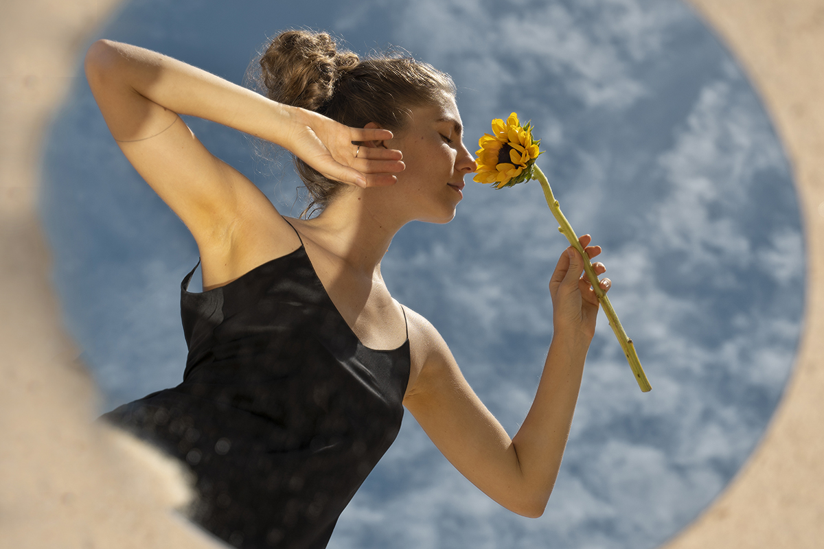 woman posing with round mirror flower