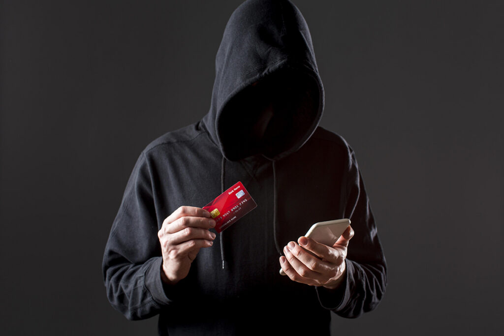 Телефонные аферисты в действии: милиция рассказала, как их вычислить 2 front view male hacker holding smartphone credit card