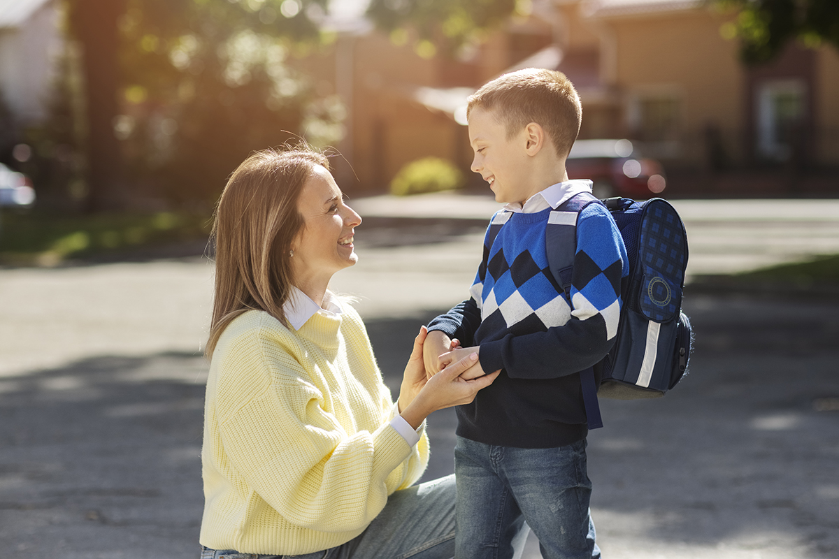 mother kid first school day side view
