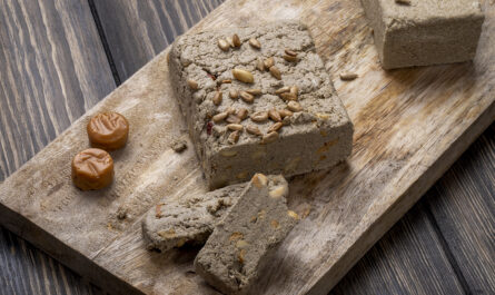 side view tasty halva with sunflower seeds wooden board