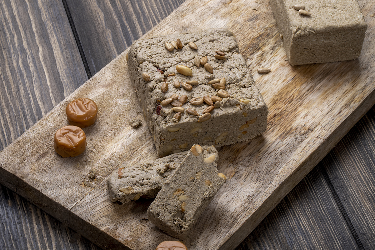side view tasty halva with sunflower seeds wooden board