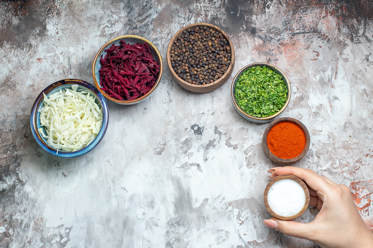 top view different seasonings with sliced cabbage greens beet white background