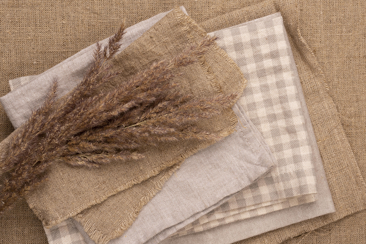flat lay monochromatic selection textiles with dried grass