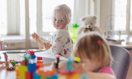 little girl drawing sitting table