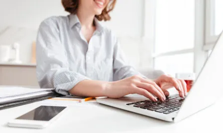 brunette woman typing email laptop computer while sitting home selective focus hand