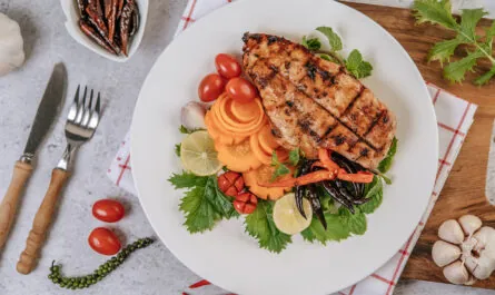 chicken steak with lemon tomato chili carrot white plate