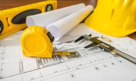 construction plans with yellow helmet drawing tools bluep