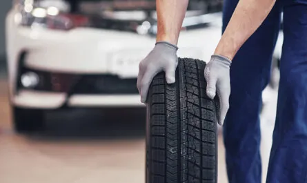 mechanic holding tire tire repair garage replacement winter summer tires