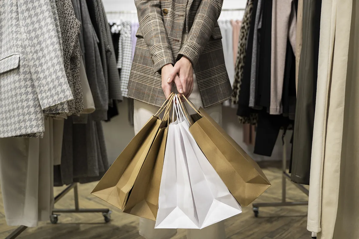 close up hands holding shopping bags