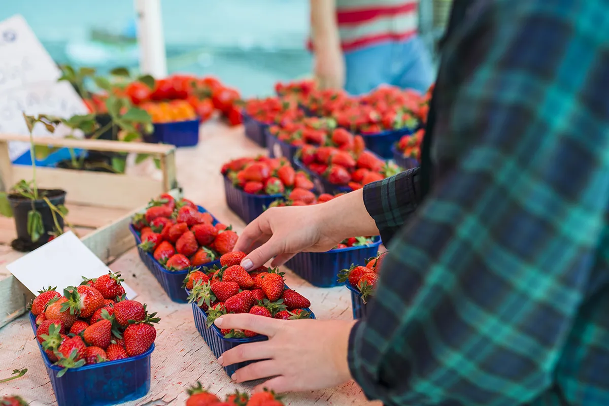 person buying strawberries supermarket