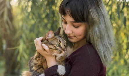 young beautiful woman with her lovely tabby cat park