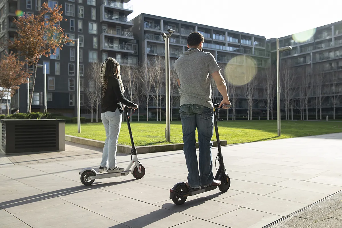 full shot people traveling with electric scooters